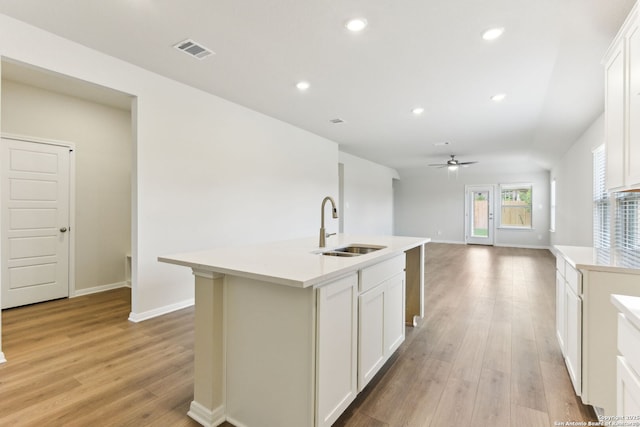 10214 King Robert, San Antonio, TX 78239 - kitchen featuring a sink, ceiling fan, light wood-style floors, baseboards, and white cabinetry