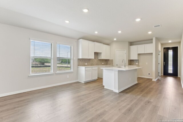 10214 King Robert, San Antonio, TX 78239 - kitchen featuring a sink, decorative backsplash, a kitchen island with sink, light wood-style floors, and recessed lighting