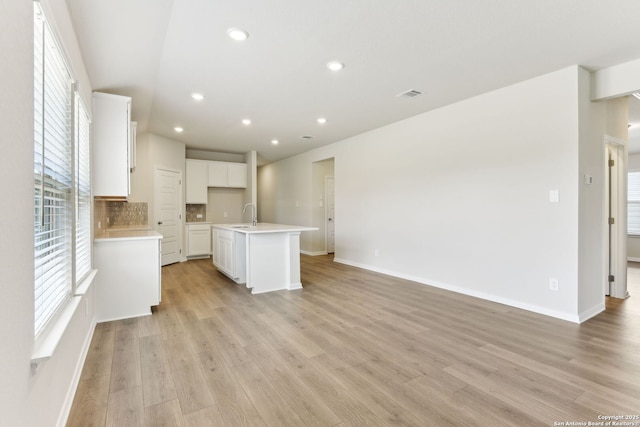 10214 King Robert, San Antonio, TX 78239 - unfurnished living room featuring a sink, light wood finished floors, baseboards, and recessed lighting