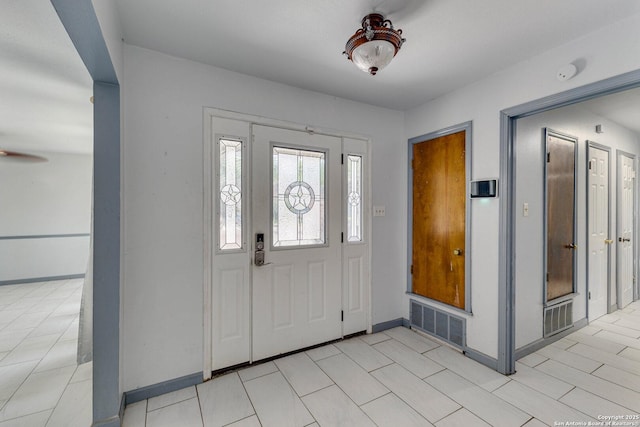 foyer featuring visible vents, baseboards, and a ceiling fan