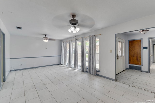 spare room with visible vents, baseboards, and a ceiling fan