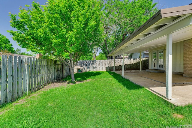 view of yard with a patio area, french doors, and a fenced backyard