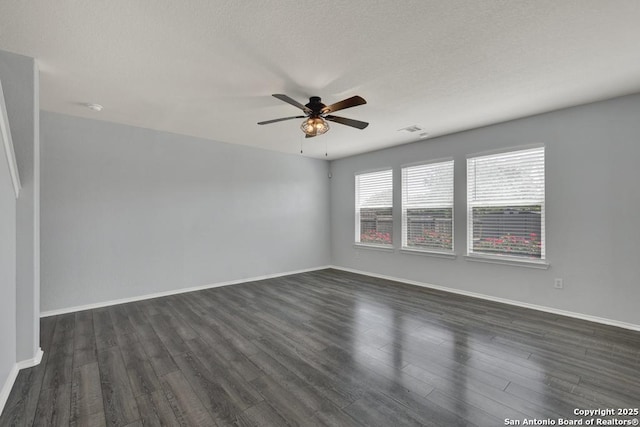 unfurnished room featuring dark wood-type flooring, visible vents, baseboards, and ceiling fan