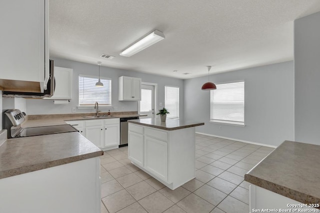 kitchen featuring stainless steel dishwasher, stove, white cabinetry, a sink, and hanging light fixtures