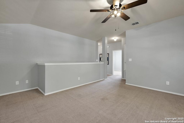 spare room with baseboards, carpet flooring, visible vents, lofted ceiling, and ceiling fan