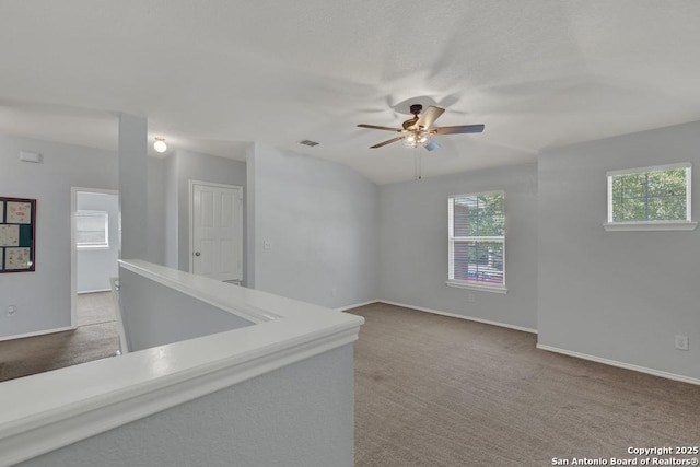 carpeted empty room featuring visible vents, baseboards, and ceiling fan