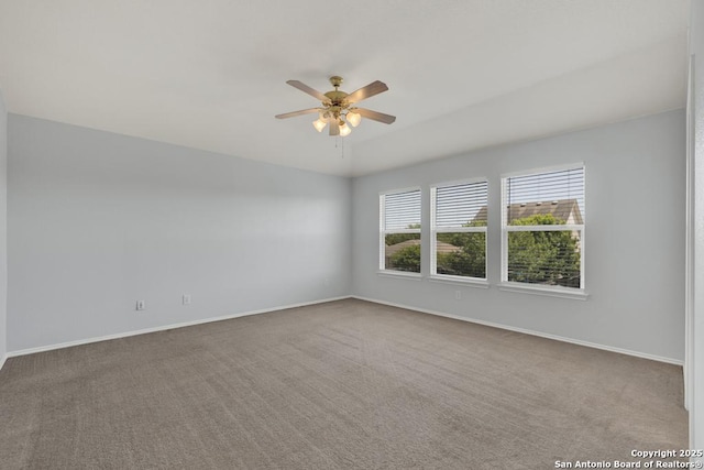 carpeted spare room with ceiling fan and baseboards