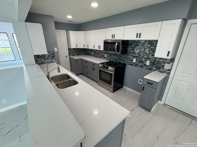2410 Townbreeze, San Antonio, TX 78238 - kitchen with a sink, gray cabinetry, light stone countertops, decorative backsplash, and stainless steel appliances