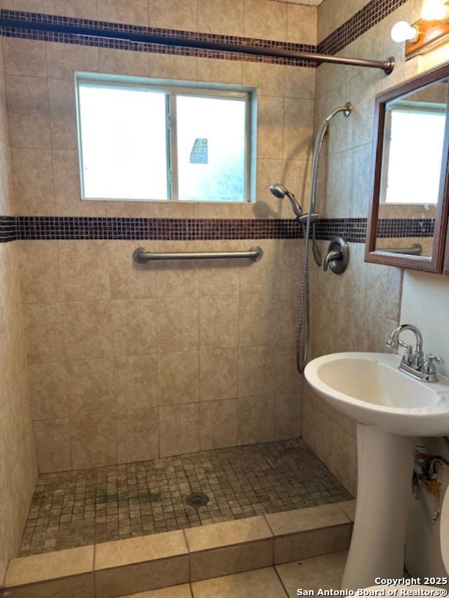 726 Southcross, San Antonio, TX 78211 - full bathroom featuring a sink, tile walls, and tiled shower