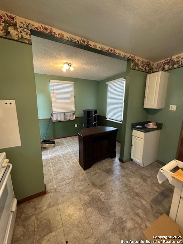 726 Southcross, San Antonio, TX 78211 - kitchen with a textured ceiling, stove, a healthy amount of sunlight, and white cabinetry