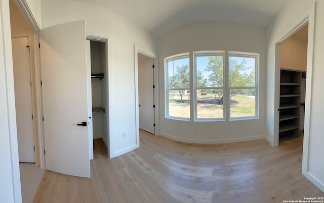 707 Lone Cir, San Antonio, TX 78260 - unfurnished bedroom with light wood-type flooring, a closet, baseboards, and a walk in closet