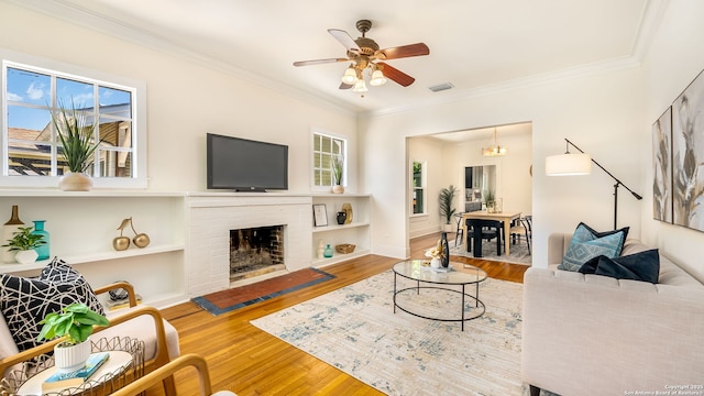 315 Carnahan, San Antonio, TX 78209 - living area featuring visible vents, a brick fireplace, ceiling fan, crown molding, and wood finished floors