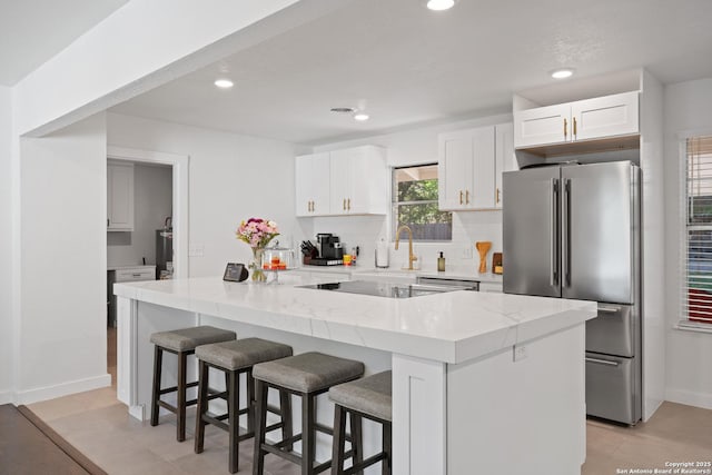 2727 Belvoir, San Antonio, TX 78230 - kitchen with high end fridge, recessed lighting, white cabinetry, and a kitchen bar