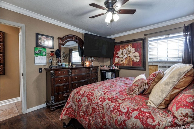 bedroom with baseboards, cooling unit, crown molding, ceiling fan, and wood finished floors