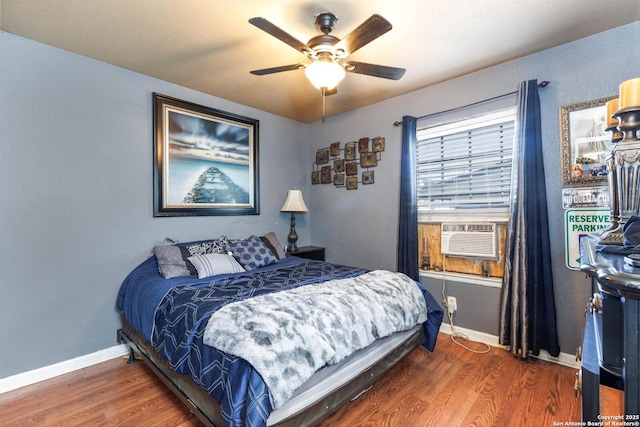 bedroom with ceiling fan, baseboards, and wood finished floors