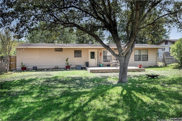rear view of house featuring a yard, fence, and a patio area