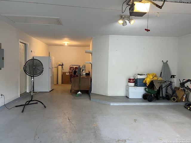 garage with a garage door opener, electric panel, and freestanding refrigerator