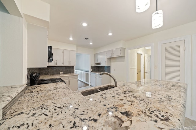 3918 Midvale, San Antonio, TX 78229 - kitchen with black / electric stove, a sink, light stone counters, decorative backsplash, and a peninsula