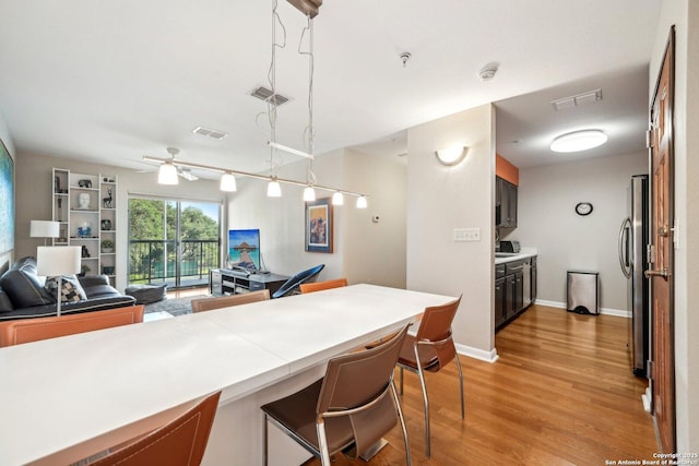 4111 Medical Dr Unit A 204, San Antonio, TX 78229 - kitchen featuring freestanding refrigerator, light countertops, light wood-style floors, a breakfast bar area, and a ceiling fan