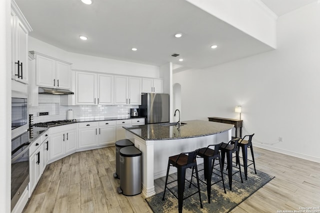 1105 Limestone, New Braunfels, TX 78132 - kitchen featuring under cabinet range hood, a center island with sink, a kitchen bar, appliances with stainless steel finishes, and a sink