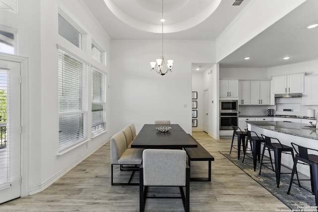 1105 Limestone, New Braunfels, TX 78132 - dining area featuring a notable chandelier, baseboards, recessed lighting, light wood-style flooring, and a raised ceiling