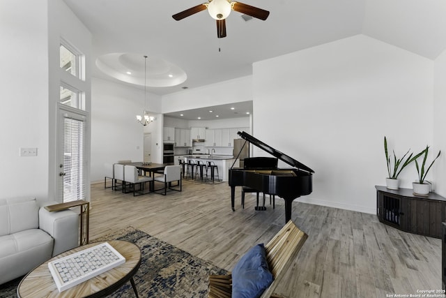 1105 Limestone, New Braunfels, TX 78132 - living area featuring baseboards, recessed lighting, light wood-style flooring, a high ceiling, and ceiling fan with notable chandelier