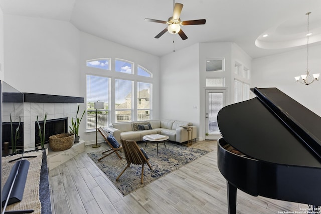 1105 Limestone, New Braunfels, TX 78132 - living room featuring light wood-type flooring, recessed lighting, a fireplace, a high ceiling, and ceiling fan with notable chandelier