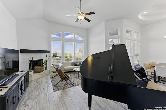 1105 Limestone, New Braunfels, TX 78132 - interior space with a tile fireplace, a towering ceiling, light wood-type flooring, and a ceiling fan
