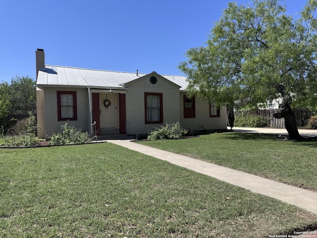 ranch-style house with a front yard, metal roof, and a chimney