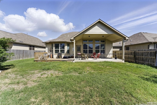rear view of property featuring a fenced backyard, a patio area, and a lawn
