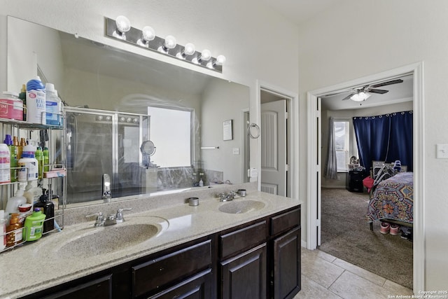 ensuite bathroom featuring a sink, tile patterned flooring, a ceiling fan, and a stall shower