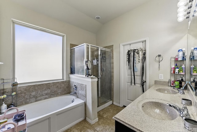 bathroom with a shower stall, double vanity, a garden tub, and a sink