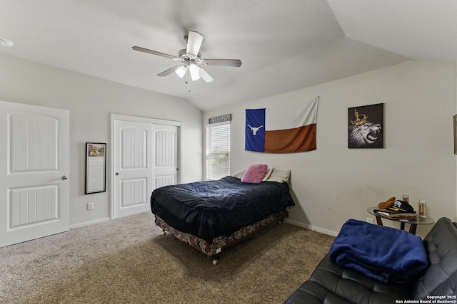 carpeted bedroom with baseboards, a closet, vaulted ceiling, and a ceiling fan