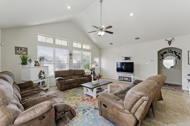 living area with high vaulted ceiling, visible vents, baseboards, and a ceiling fan