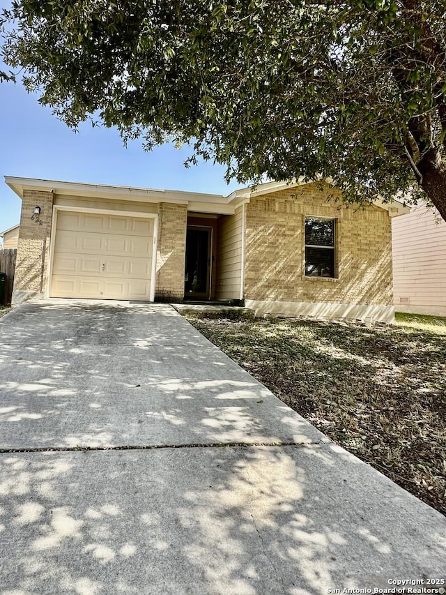 view of front facade featuring brick siding, driveway, and a garage