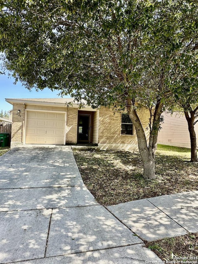 view of front facade with driveway, a garage, and brick siding
