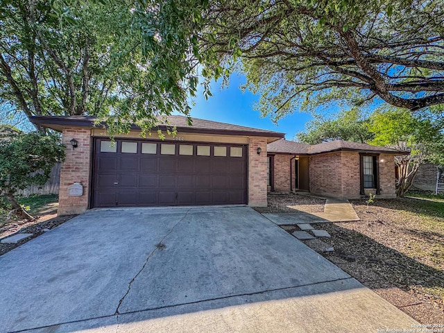 ranch-style home with brick siding, a garage, and concrete driveway
