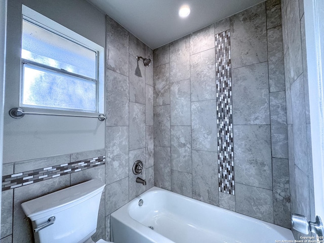bathroom with recessed lighting, tile walls, toilet, and shower / washtub combination
