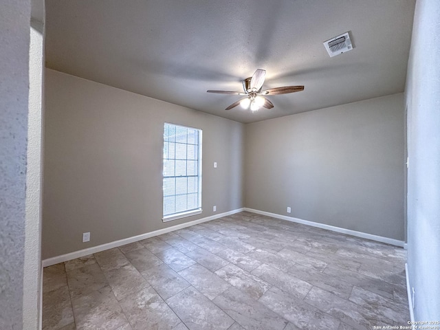 unfurnished room featuring visible vents, ceiling fan, and baseboards