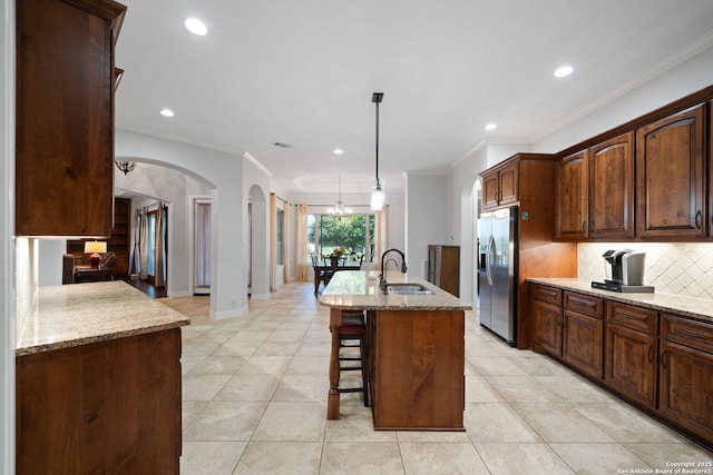 kitchen featuring a sink, ornamental molding, tasteful backsplash, and stainless steel fridge