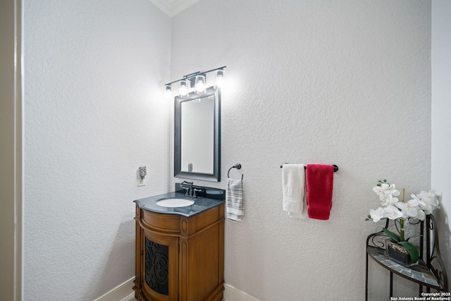 bathroom with crown molding, vanity, and baseboards