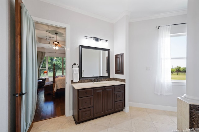 ensuite bathroom with vanity, ensuite bath, ornamental molding, a ceiling fan, and baseboards