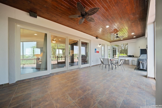 view of patio / terrace with exterior kitchen, outdoor dining space, and ceiling fan