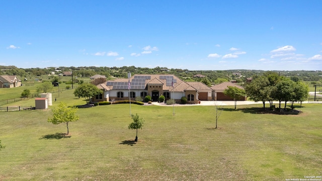 view of front of property with a tiled roof, driveway, a front yard, and solar panels