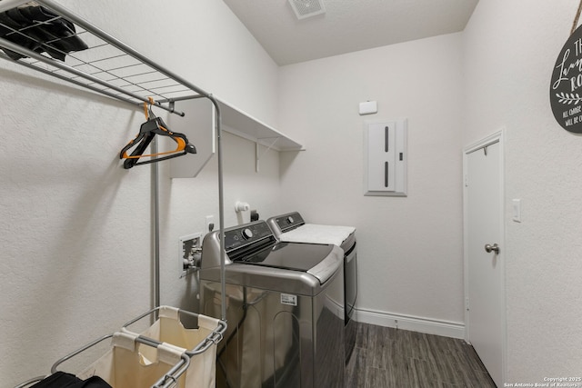 washroom with laundry area, electric panel, washing machine and clothes dryer, baseboards, and dark wood-style floors