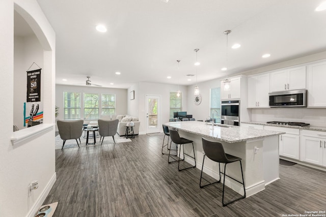 kitchen featuring white cabinetry, recessed lighting, appliances with stainless steel finishes, a kitchen island with sink, and open floor plan