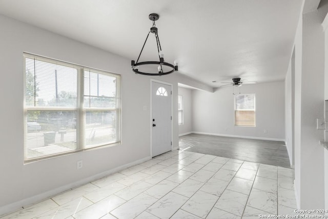 243 Alicia Ave, San Antonio, TX 78228 - interior space with ceiling fan with notable chandelier, marble finish floor, baseboards, and a healthy amount of sunlight
