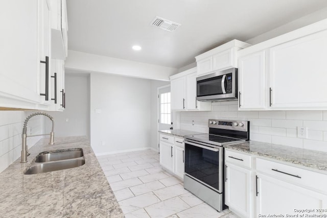 243 Alicia Ave, San Antonio, TX 78228 - kitchen featuring appliances with stainless steel finishes, light stone counters, visible vents, decorative backsplash, and a sink