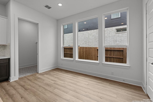 unfurnished dining area with light wood finished floors, visible vents, baseboards, and recessed lighting