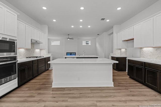 kitchen featuring white cabinetry, appliances with stainless steel finishes, a center island, and recessed lighting